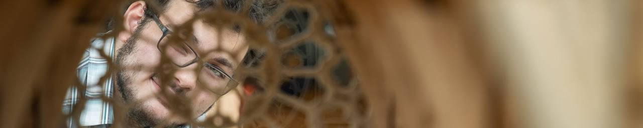 Student seen through a sculpture.